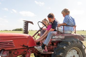 vader leert dochter tractorrijden