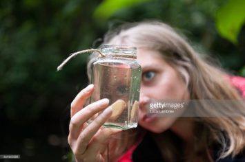 Vrouw bestudeert een potje slootwater
